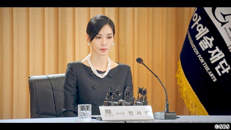 マイクのある席に座る女性