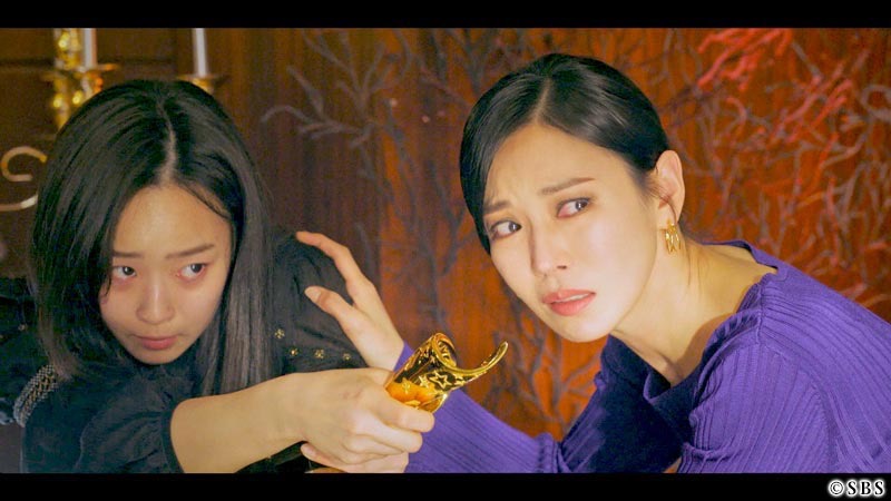 しゃがみ込んで同じ方向を向いている女性2人