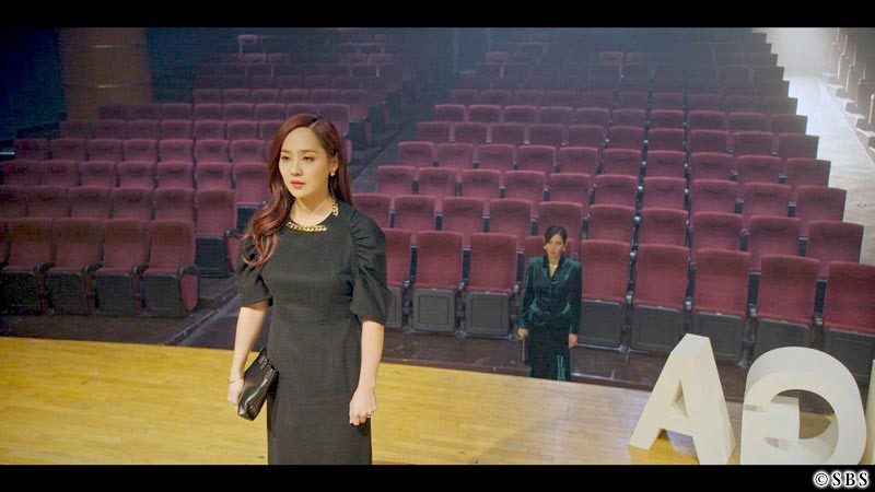 舞台に立つ女性を舞台下から見つめる女性