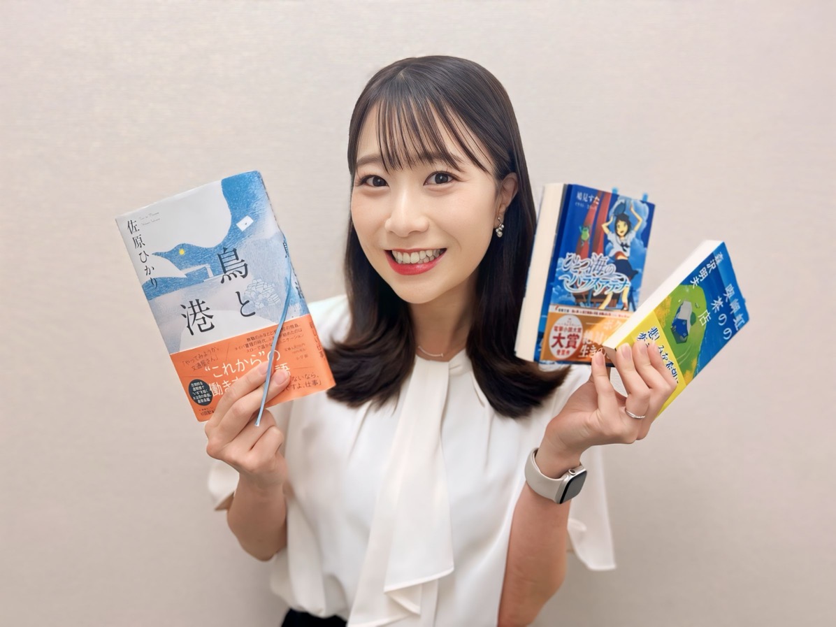 女性が3冊の本を持って紹介する様子