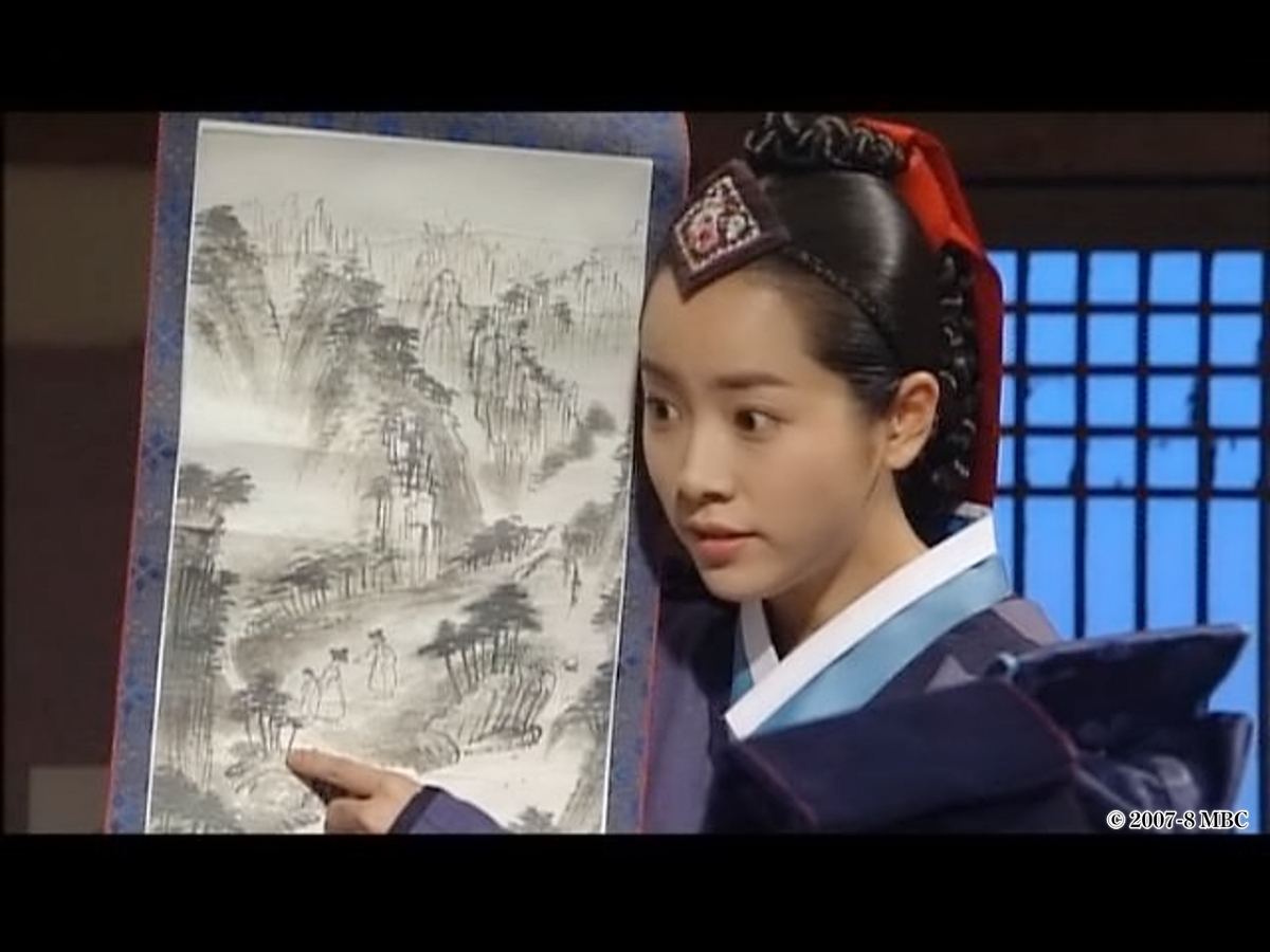 絵を指さす女性