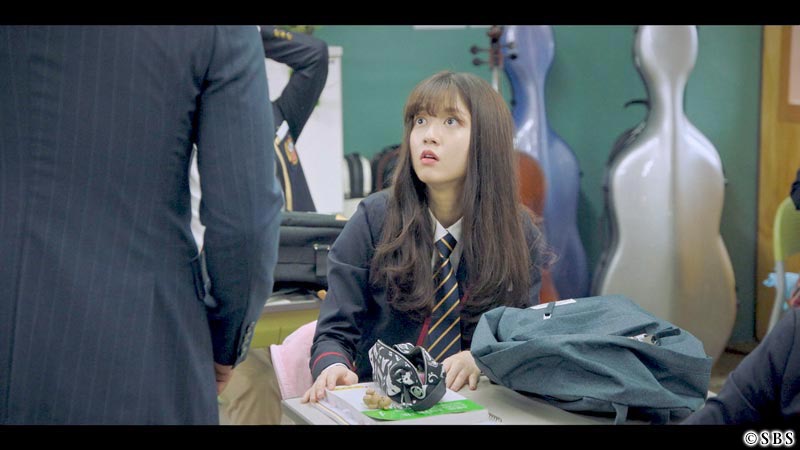 椅子に座りながら会話して驚く女性