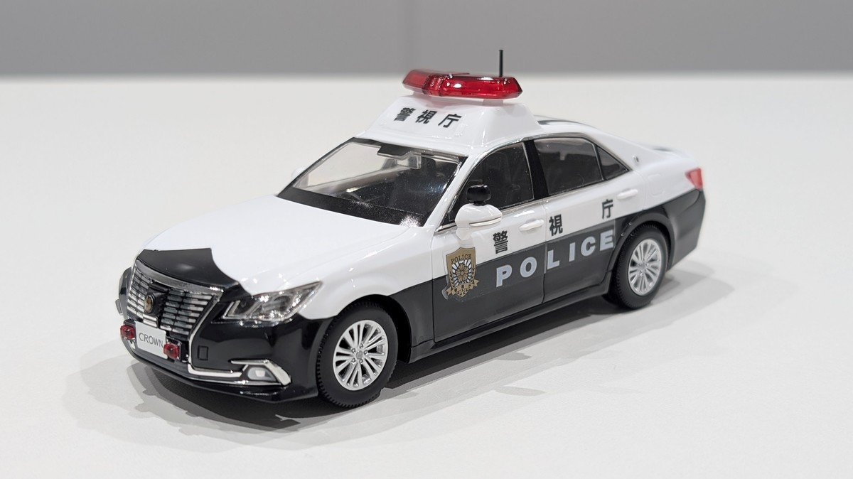 プラモデルのパトカーを手にのせた様子