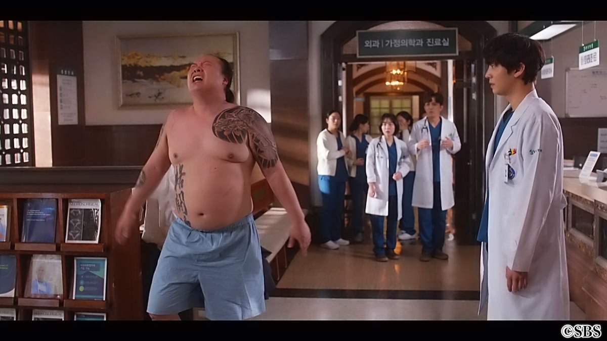 タトゥーを入れた男性を見つめる医師