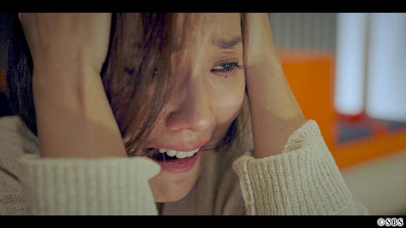 頭をかかえて涙を流す女性