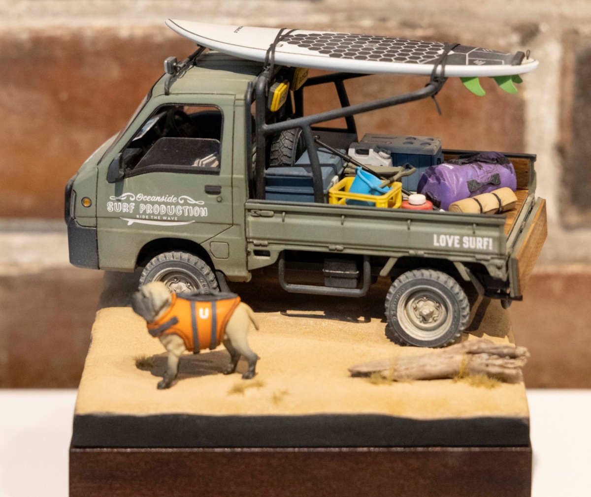 サーフボードやキャンプ用品を荷台に乗せたトラックと犬の模型