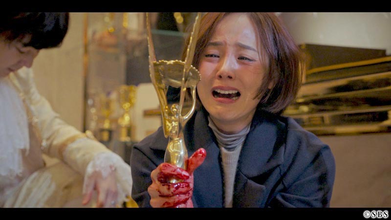 手に血がついた状態で涙を流す女性