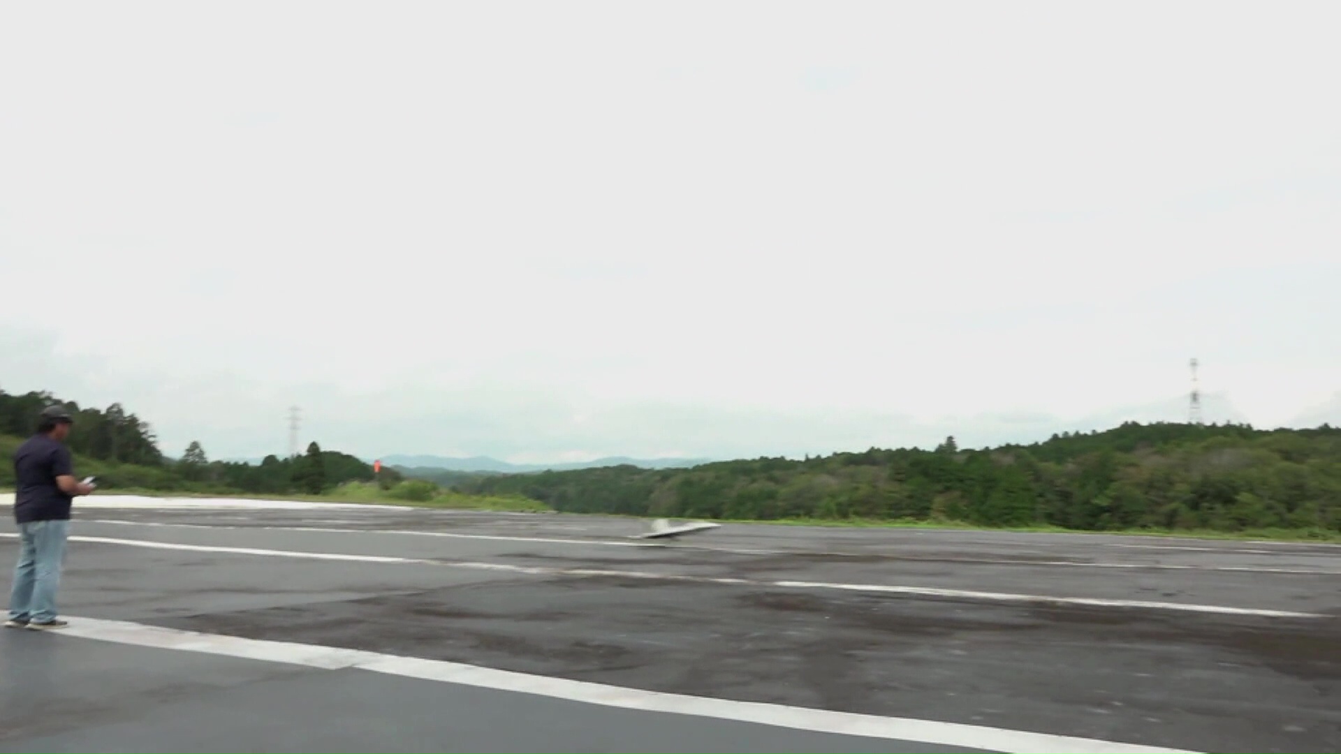 ラジコン飛行機が滑走路に着陸する様子を遠くから撮影した写真