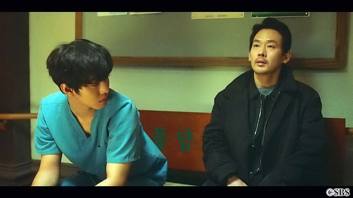 椅子に腰かけ話す医師2人