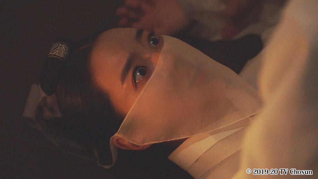 寝ながら目を見開く女性