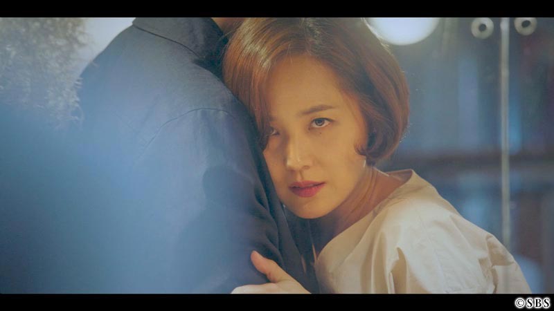 男性の肩に顔を寄せて何かを見つめる女性