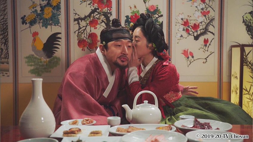 男性の耳元に手をあててささやく女性