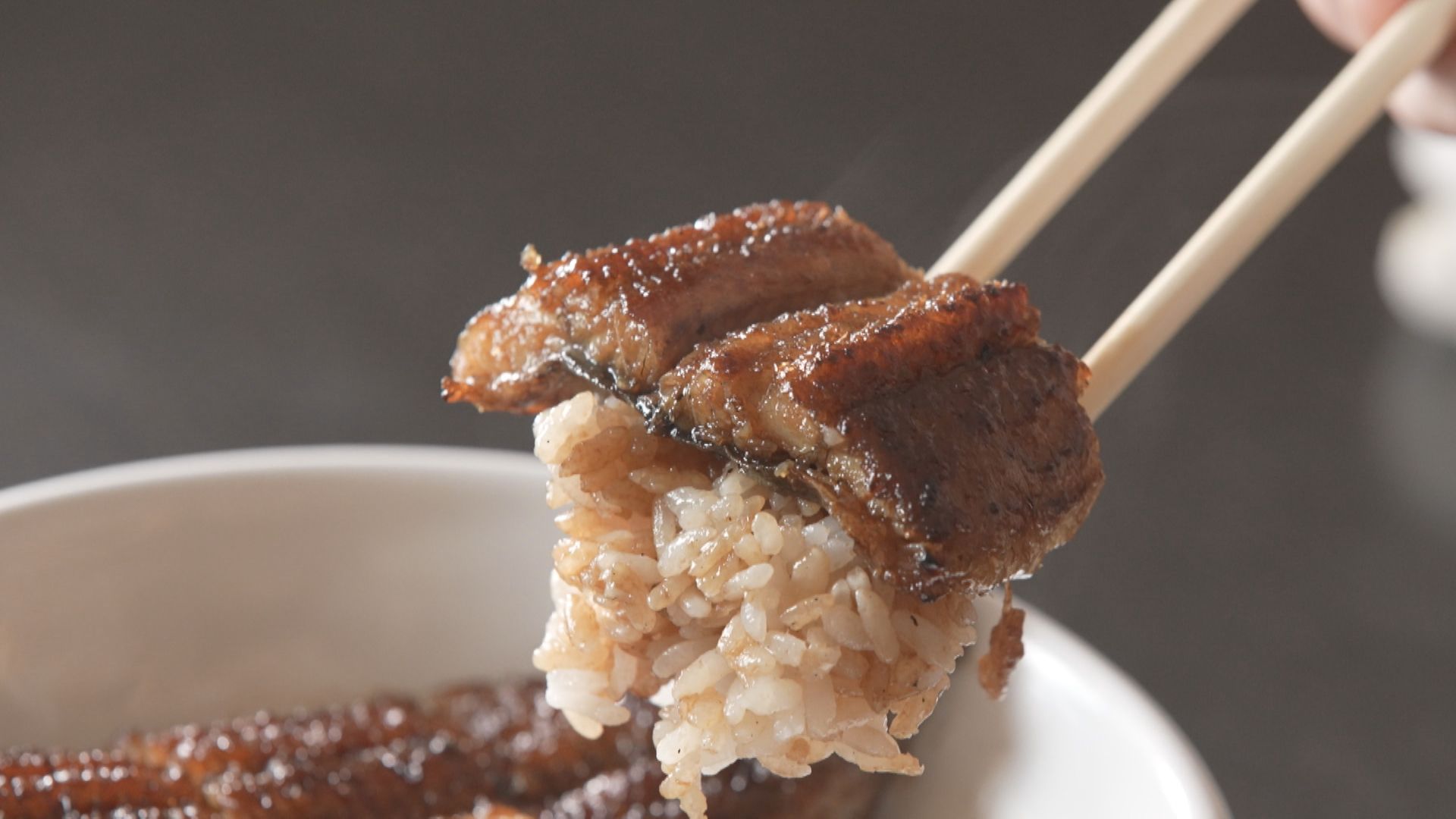 箸でつかんだ米とうなぎ
