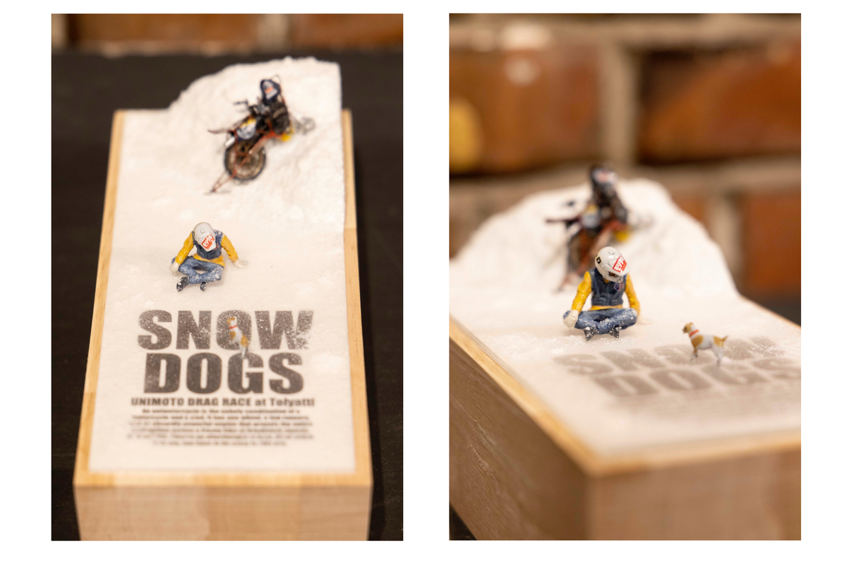 雪の上に座っている人と犬の模型