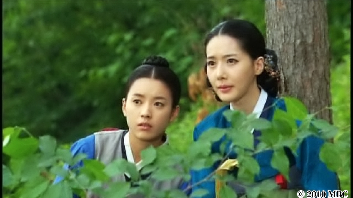 草むらからこちらをのぞき込む女性2人