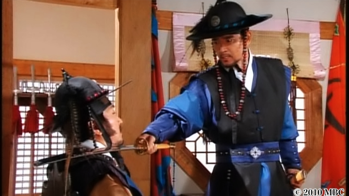 男性ののど元に剣を突き付ける男性