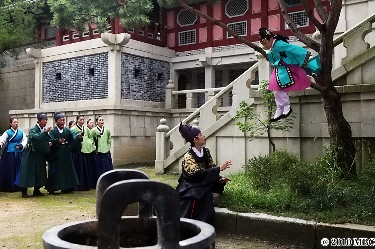 木の上に登る子供を心配する大人たち