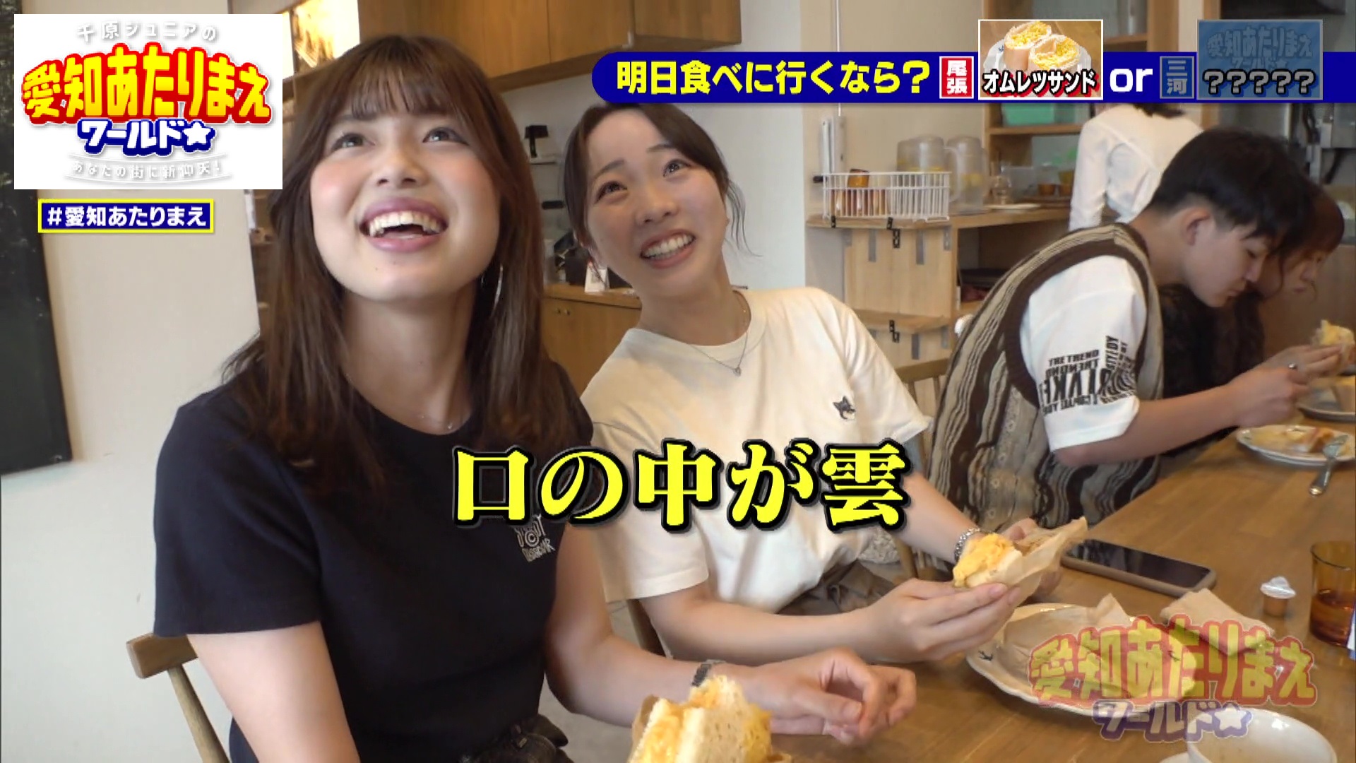 カウンターでサンドイッチを食べる女性2人組