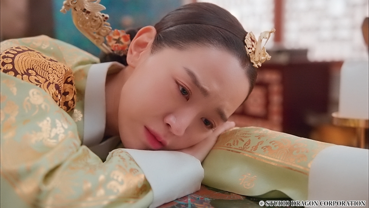 机につっぷして悩む女性