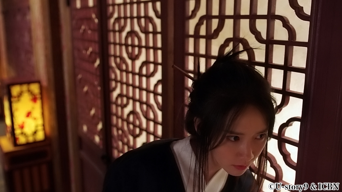 扉越しに会話を盗み聞きする女性