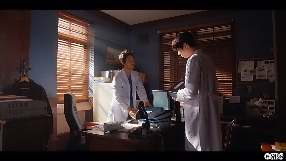 デスクで話す男性医師2人