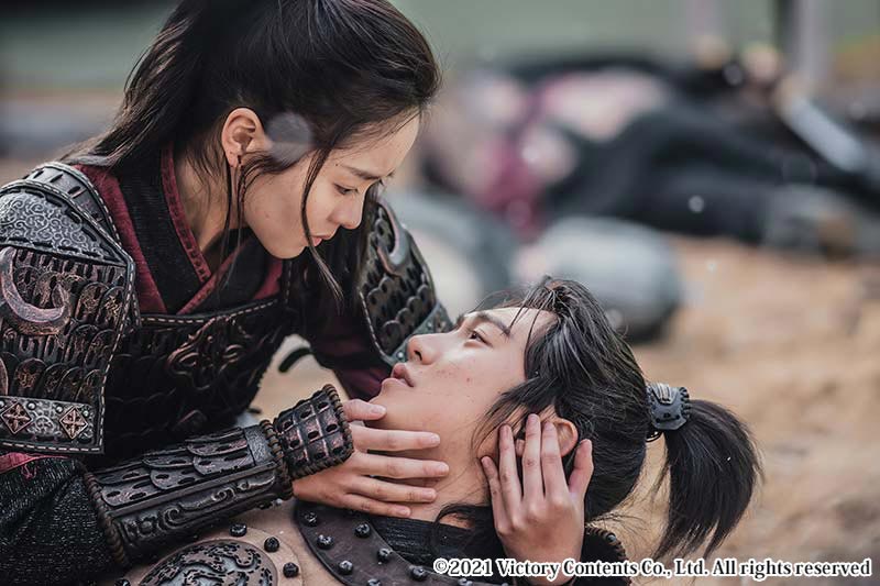 戦場で男性を抱きかかえる女性