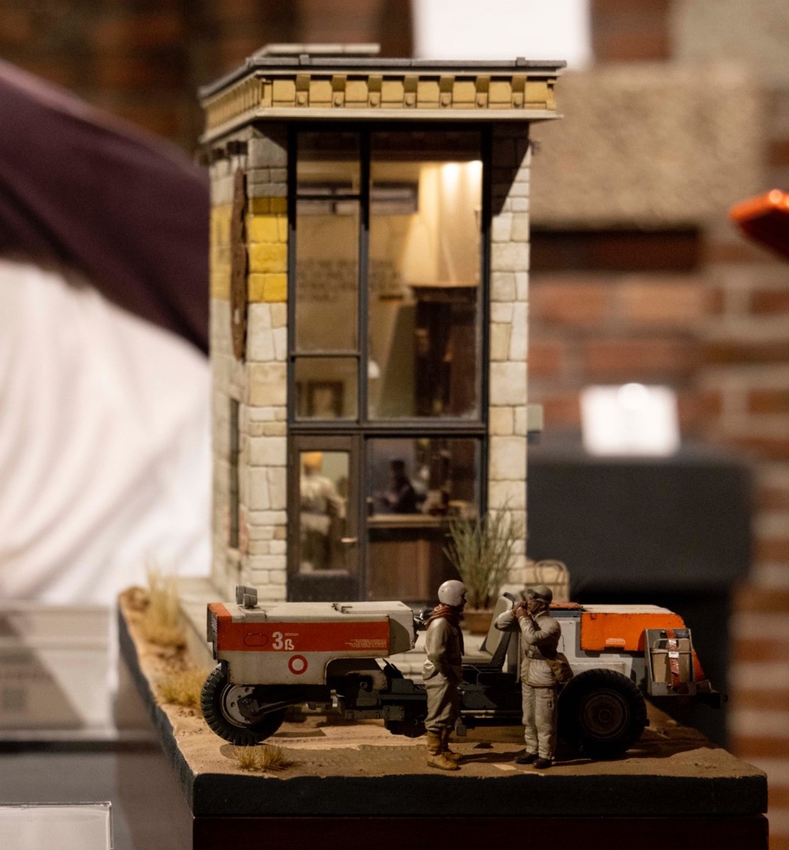 酒場の外装と、その近くにモビリティを停車させて談笑する人の模型