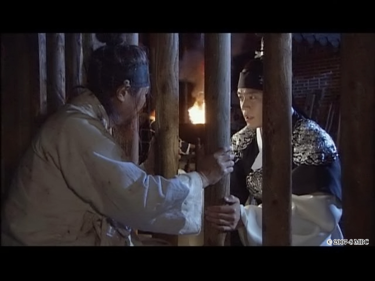 捕まっている人と話す男性