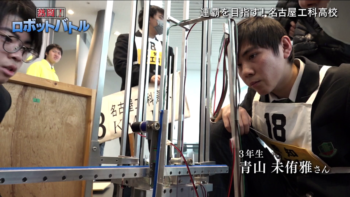 ロボットの前に座る生徒