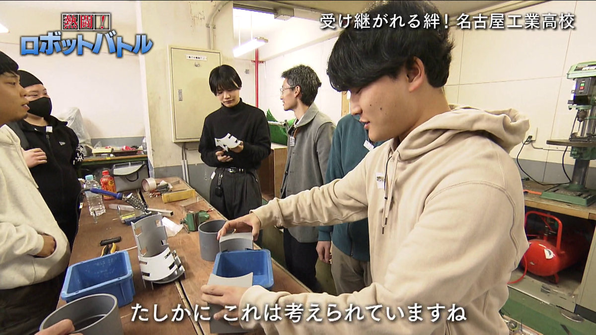 ロボットのパーツを見る男性