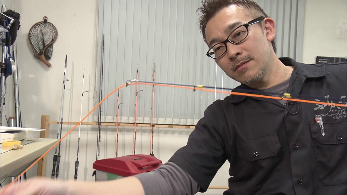 釣り竿のガイドに糸を通す様子