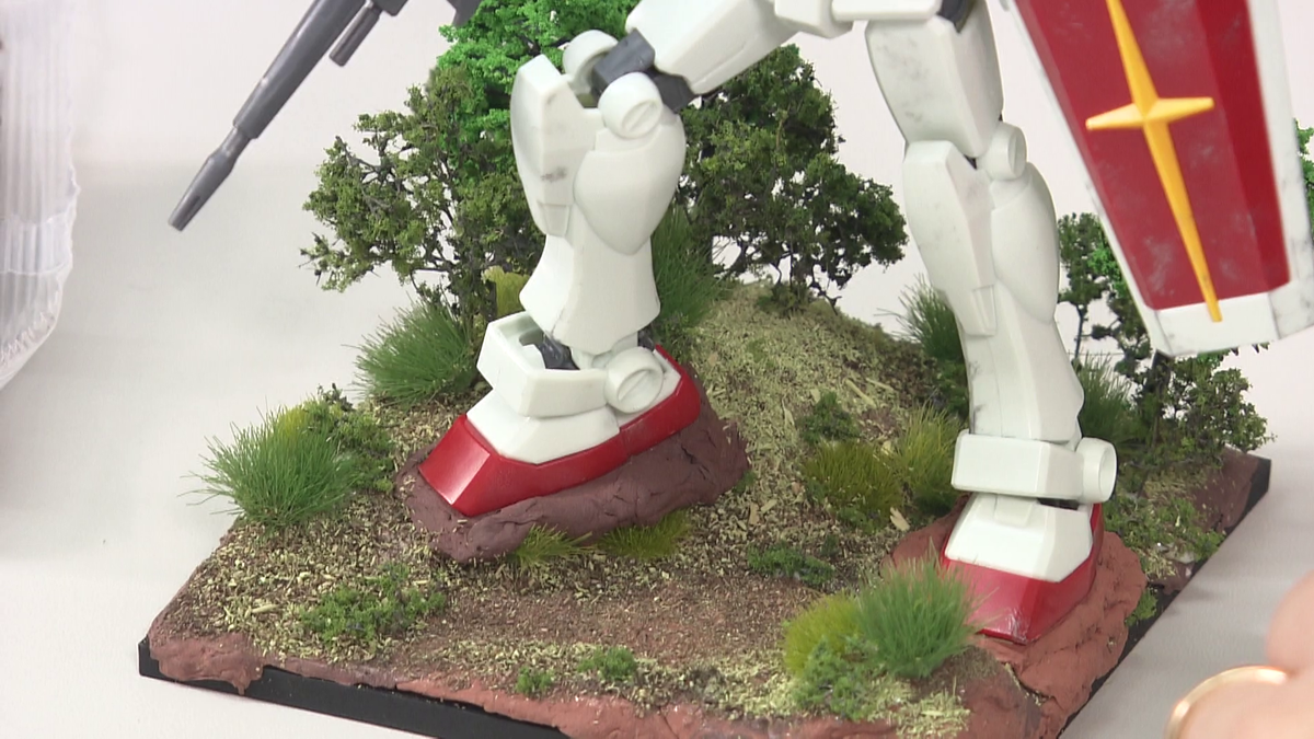 足の裏に粘土を付けてジオラマに立たせる様子